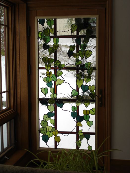 Ivy trellis themed stained glass window in a door