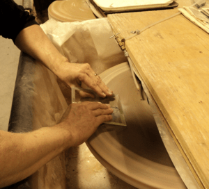 Polishing glass by hand on a sandstone wheel